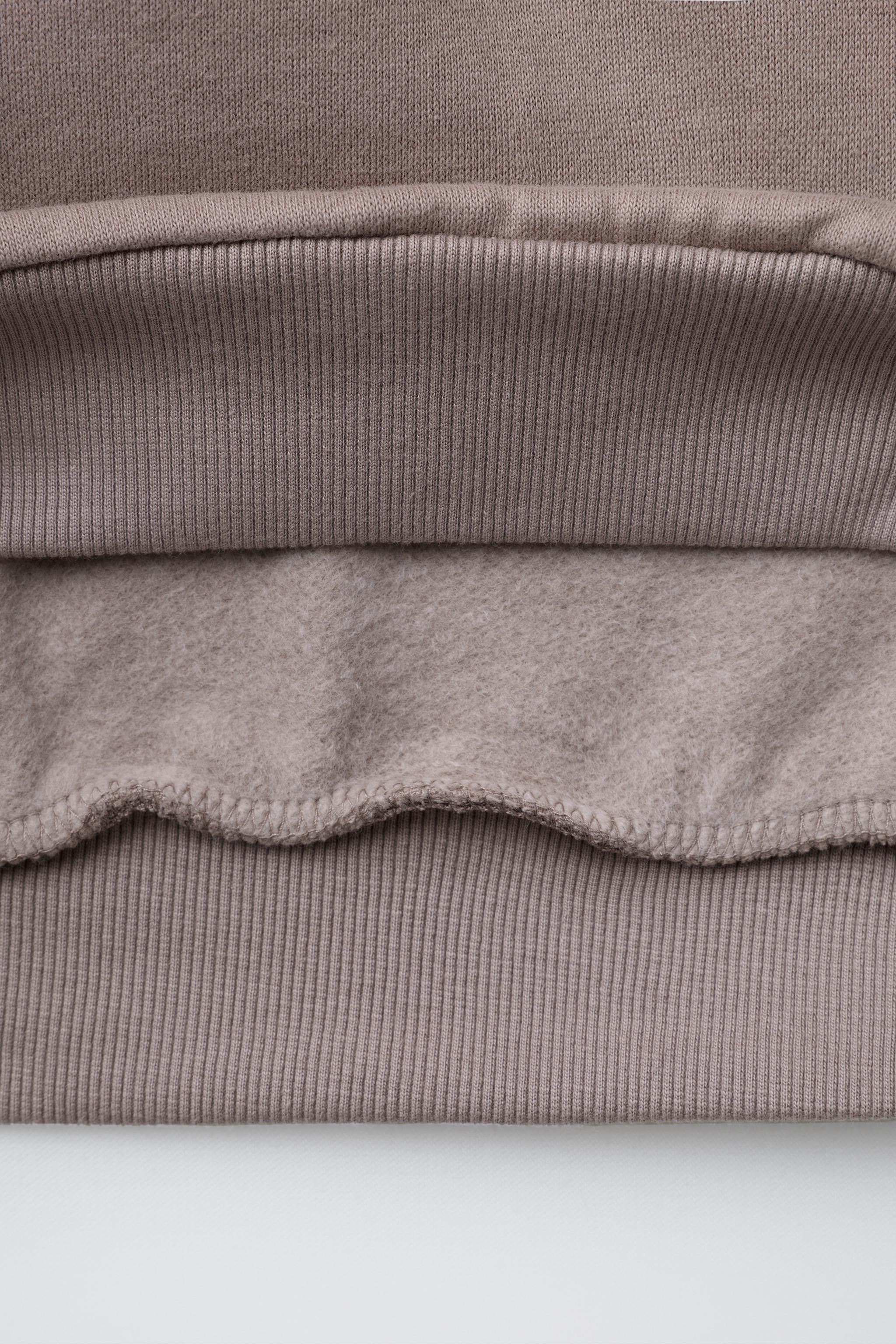 SWEAT À CAPUCHE ET INSCRIPTION